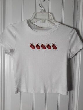 White Crop top baby tee features Red Ladybug Embroidery by Slubert.  Size S